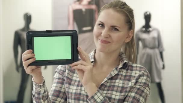 Dziewczyna pokazuje tabletki przy pomocy zielonego ekranu, w centrum handlowym - Materiał filmowy, wideo