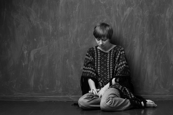 Perheväkivalta - uhri istuu lattialla
 - Valokuva, kuva