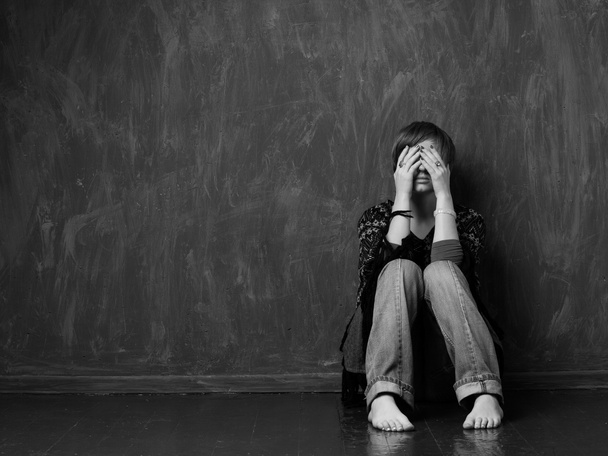 Насилие в семье безнадежная женщина сидит у стены
 - Фото, изображение