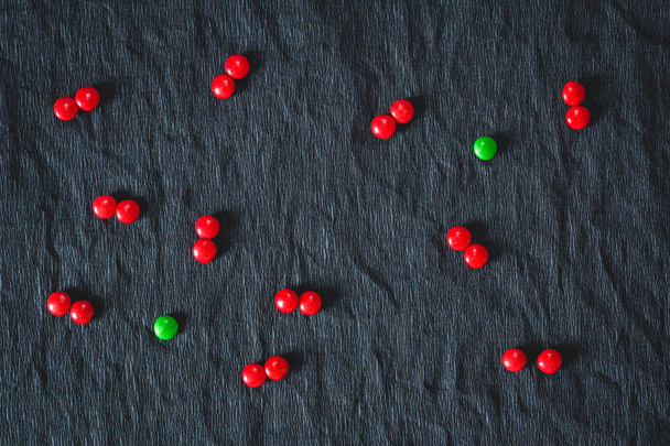 赤いお菓子に囲まれた緑のキャンディー - 写真・画像