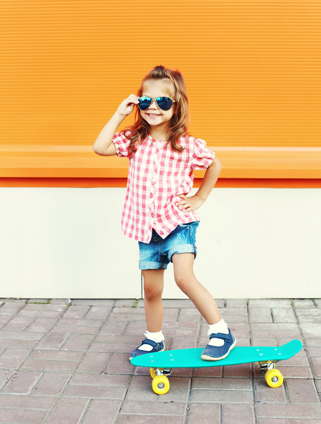 Fashion kid - smiling stylish little girl child with skateboard  - Photo, Image