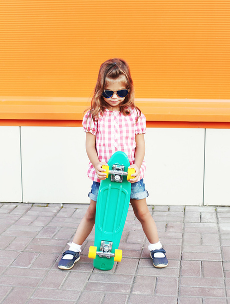 Fashion little girl child with skateboard wearing a sunglasses a - Φωτογραφία, εικόνα