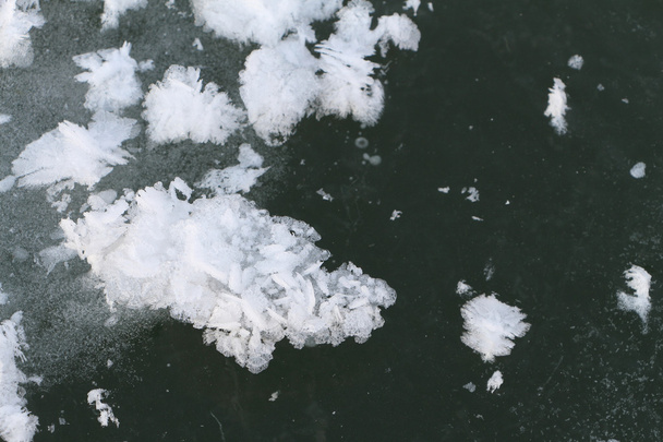Snow freakish outgrowths on ice of the frozen river - Foto, afbeelding