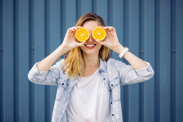 Smiling woman holding two orange in hands - Foto, immagini