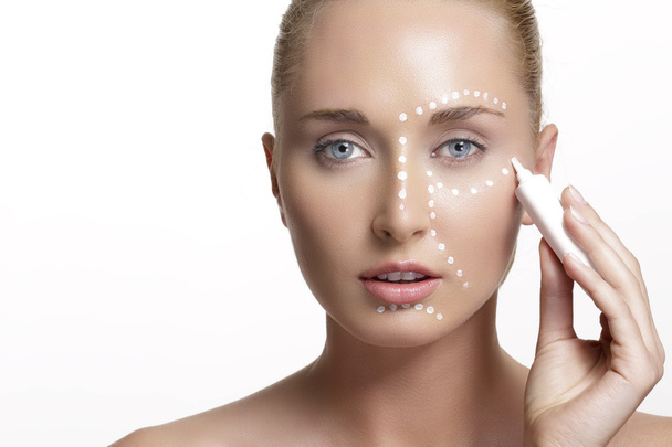 young beautiful woman applying creme on her skin - Foto, Bild