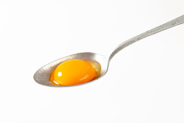 Raw egg yolk on spoon - Photo, Image