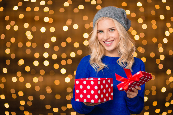 Happy woman opening gift box over holdays lights - Foto, afbeelding