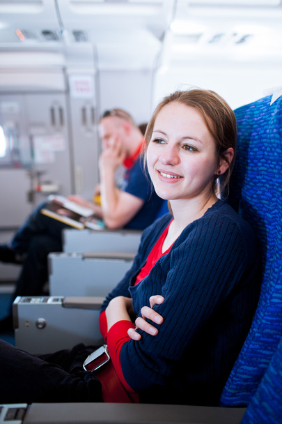 Pretty young female passenger on board of an aircraft - Fotografie, Obrázek