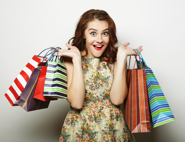 Portrait of young happy smiling woman with shopping bags - 写真・画像