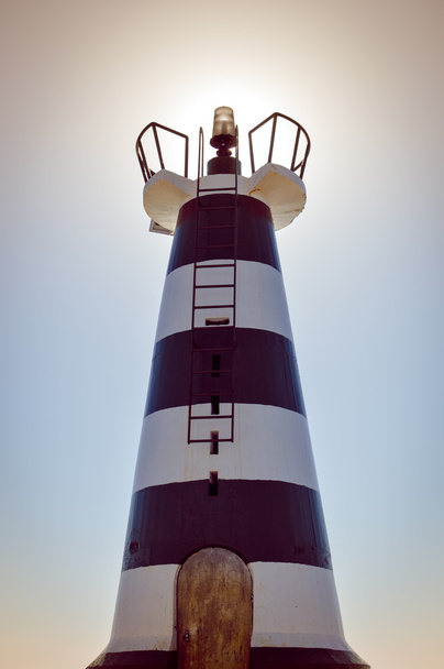 Beautiful lighthouse with bright sun light over sky background - Foto, imagen