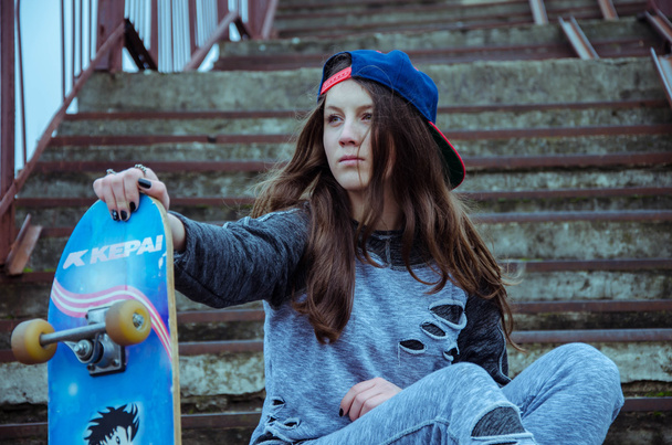 Beautiful hipster girl with skate board wearing sunglasses - Foto, imagen
