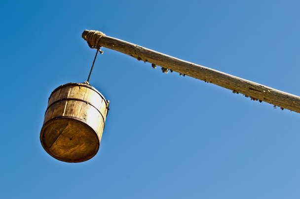 Винтажные ведро колодца против неба
 - Фото, изображение