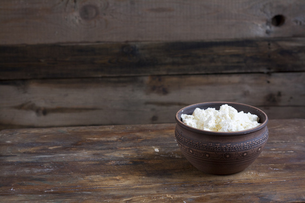 Culinary cottage cheese in a clay bowl on dark wooden table - Photo, image