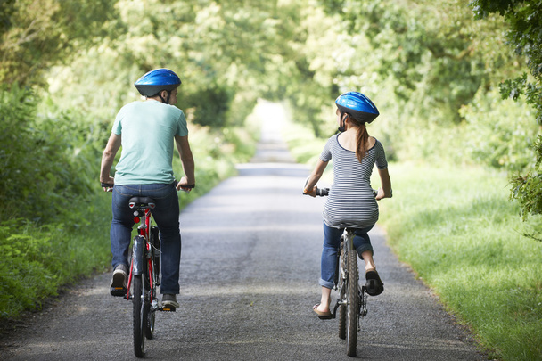 Vue arrière de jeune couple faisant du vélo sur la voie de campagne
 - Photo, image