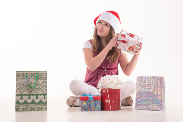 Girl teenager with a gift in a Santa hat - Foto, Bild
