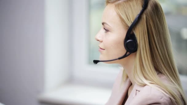 mujer de negocios con auriculares hablando en la oficina
 - Metraje, vídeo