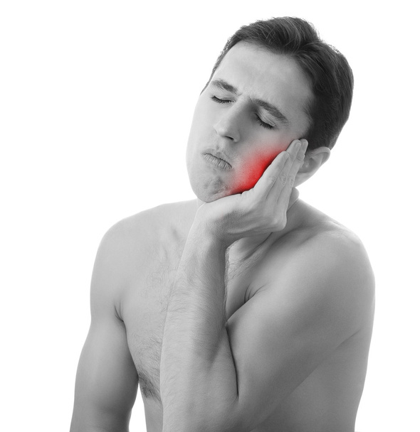 Jovem segurando seu dente dolorido na dor, isolado em ba branco
 - Foto, Imagem