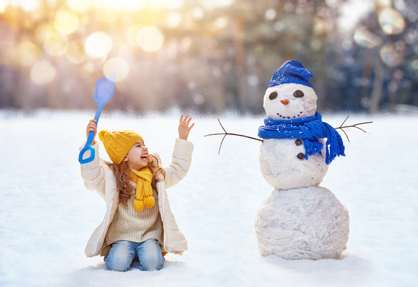 girl playing with a snowman - Fotoğraf, Görsel
