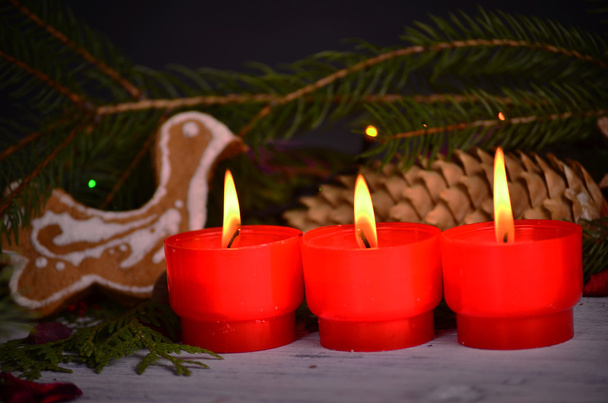  velas vermelhas com ligaduras de Natal na árvore de Natal e tangerinas na luz atmosférica
 - Foto, Imagem