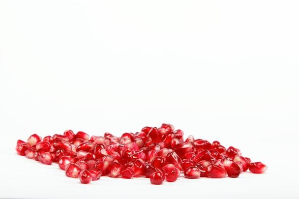 Pomegranate seeds on a white background - Foto, afbeelding