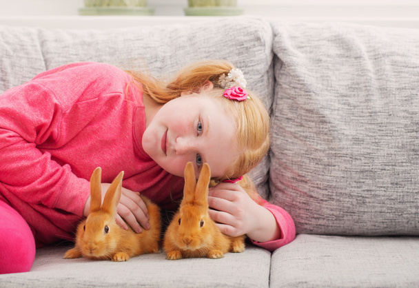 smiling girl with two rabbits indoor - Foto, immagini