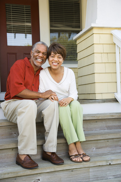 Couple Sitting on Outdoor Steps of Home Smiling - Foto, afbeelding