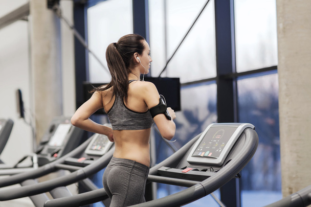 woman with earphones exercising on treadmill - Фото, зображення
