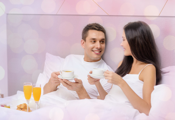 happy couple having breakfast in bed at hotel - Фото, зображення