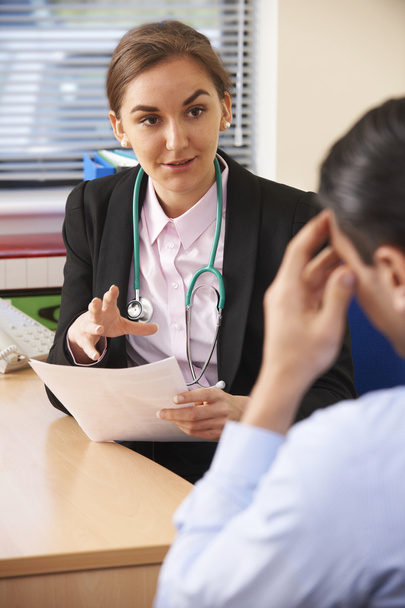 Médecin féminin ayant une discussion avec le patient masculin au bureau
 - Photo, image