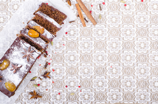 Chcolate spices cake with star anise and dried fruits, cinnamon, cloves, cardamom, handmade milk chocolate with nuts on sackcloth, canvas. Sweet frame. Free space for your text. - Foto, Imagen