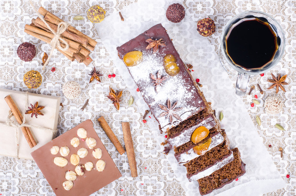 Chcolate spices cake with star anise and dried fruits, cinnamon, cloves, cardamom, handmade milk chocolate with nuts, mulled wine on sackcloth, canvas.  - Foto, Imagem