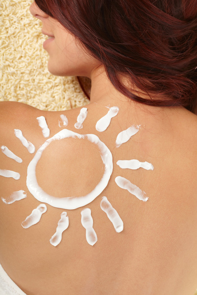 Woman with sun-shaped sun cream - Фото, зображення
