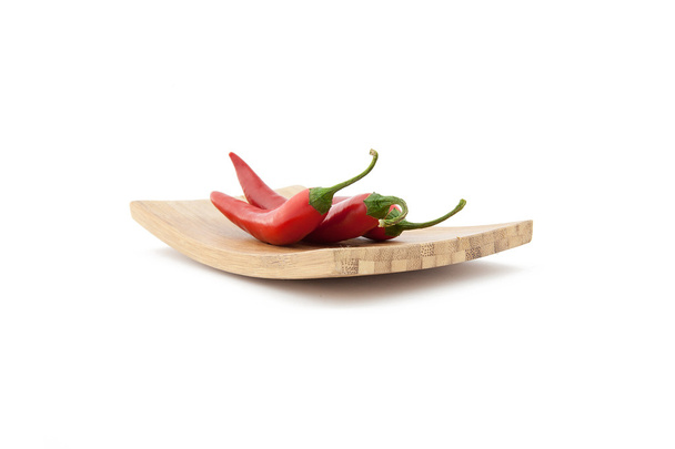 Punaiset chili-paprikat puulaudalla
 - Valokuva, kuva
