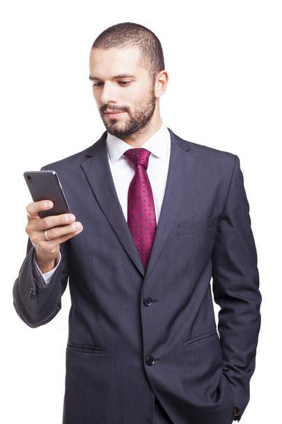 Handsome businessman reading a message on his smartphone - Фото, зображення