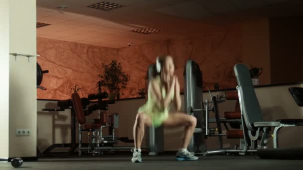 Mujer haciendo ejercicio deportivo sentadillas y saltos
 - Imágenes, Vídeo