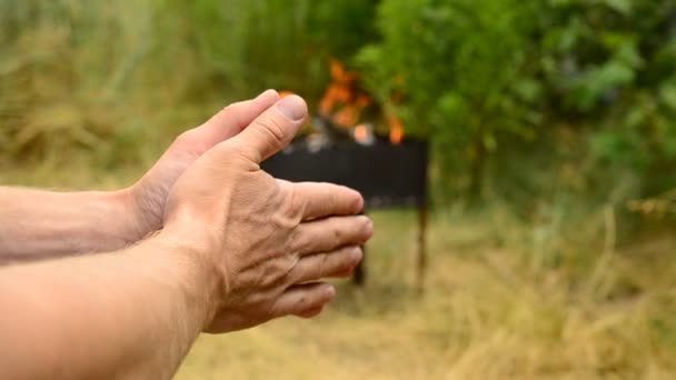 Ręce człowieka z ogniem w Kociołek na tle - Materiał filmowy, wideo