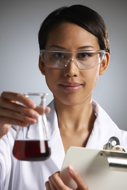 Female Scientist Examining Liquid In Flask - Photo, image