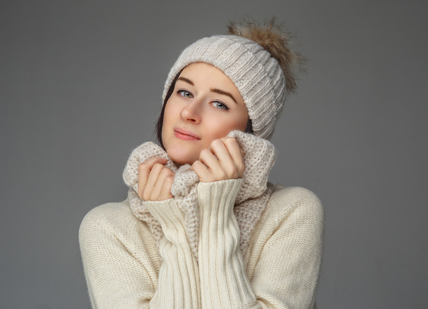  Vrouw in witte trui en winter hoed. - Foto, afbeelding