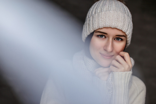  Γυναίκα στο λευκό πουλόβερ και καπέλο του χειμώνα. - Φωτογραφία, εικόνα