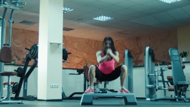 Giovane ragazza che fa squat e salta sul passo fitness
 - Filmati, video