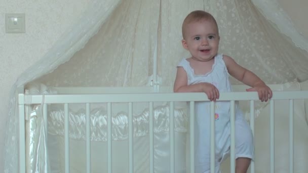 Aranyos kis baba lány állt az ágyon. FullHD videóinak - Felvétel, videó