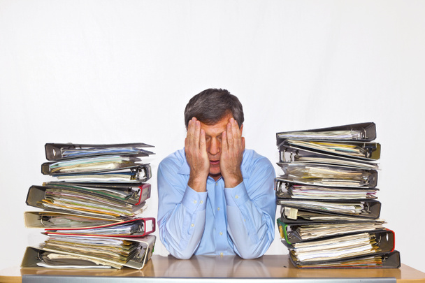 άνθρωπος μελέτες φάκελο με τα αρχεία στο γραφείο του στο γραφείο - Φωτογραφία, εικόνα