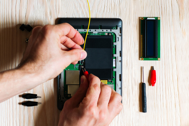 Techniker repariert Tablet-Computer auf Holzgrund - Foto, Bild
