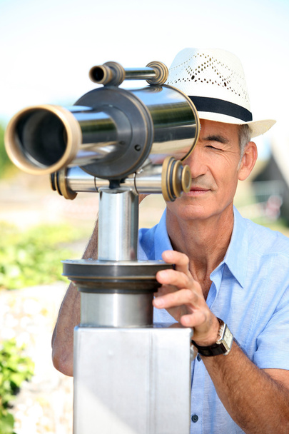 Man looking through telescope - Photo, image