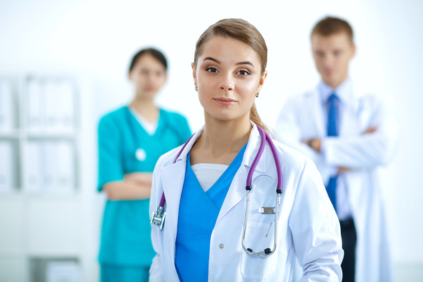 Houkutteleva naislääkäri lääketieteellisen ryhmän edessä - Valokuva, kuva
