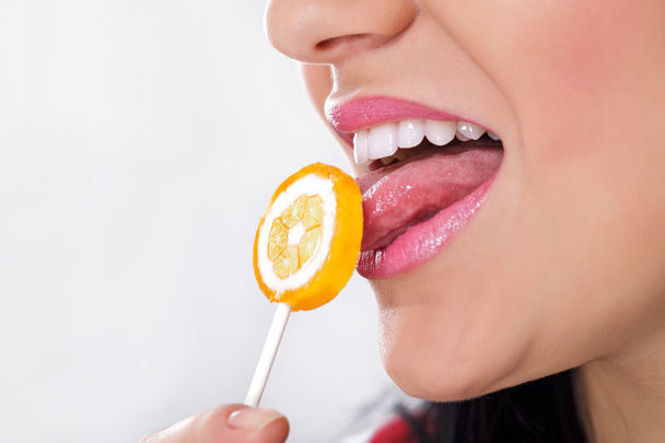 Pretty woman licking candy - Fotó, kép