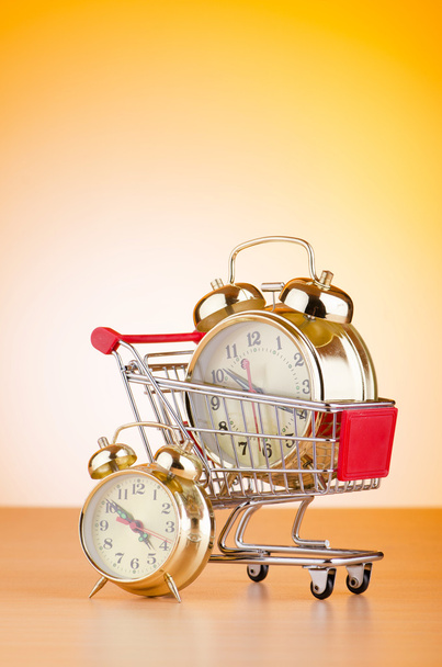 Buying time concept with clock and shopping cart - Photo, Image