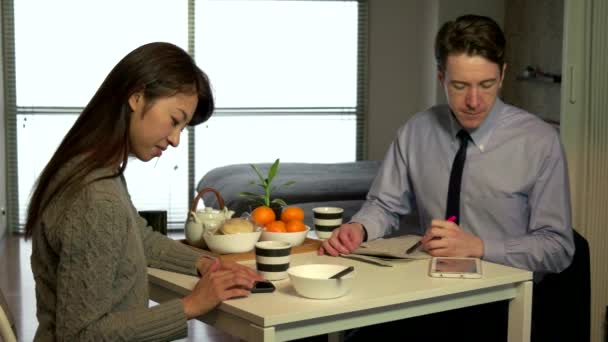 ocupado blanco gerente trabajando y desayunando con asiático esposa
 - Metraje, vídeo