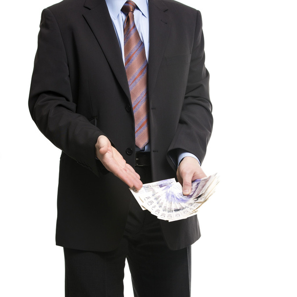 Бізнесмен в темному костюмі показує на поширення з 20 британські фунти к - Фото, зображення
