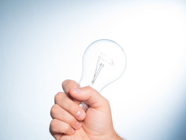 Hand holding an incandescent light bulb - Φωτογραφία, εικόνα